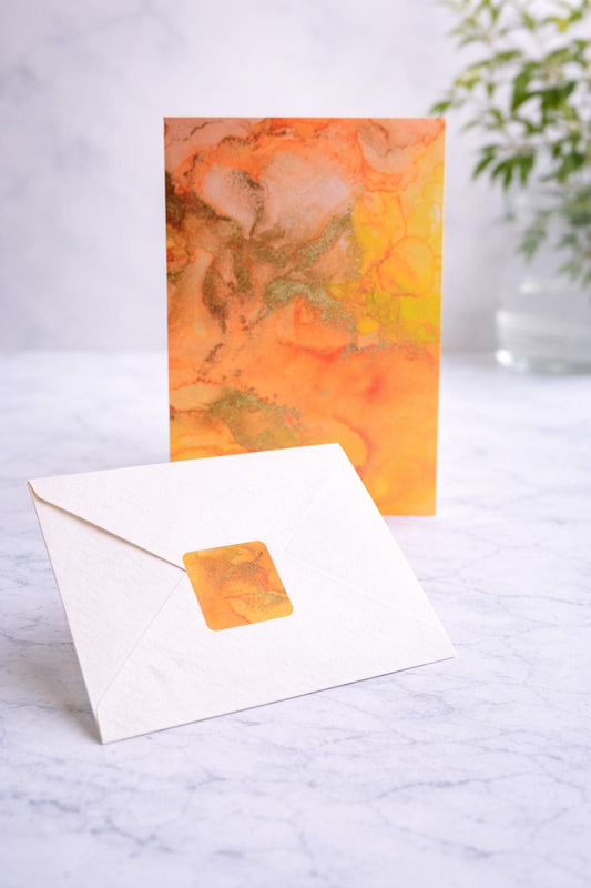 Gold topaz greeting card with matching envelope sticker on marble table
