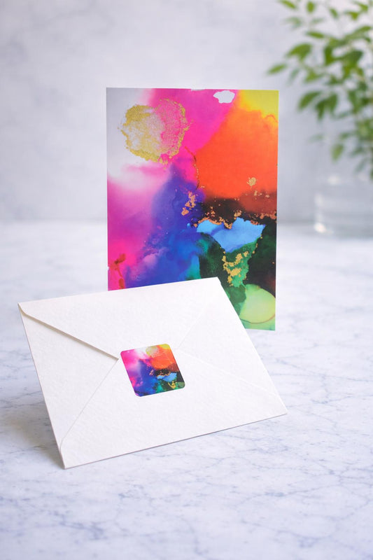 Colorful abstract greeting card with a matching envelope on a light surface.