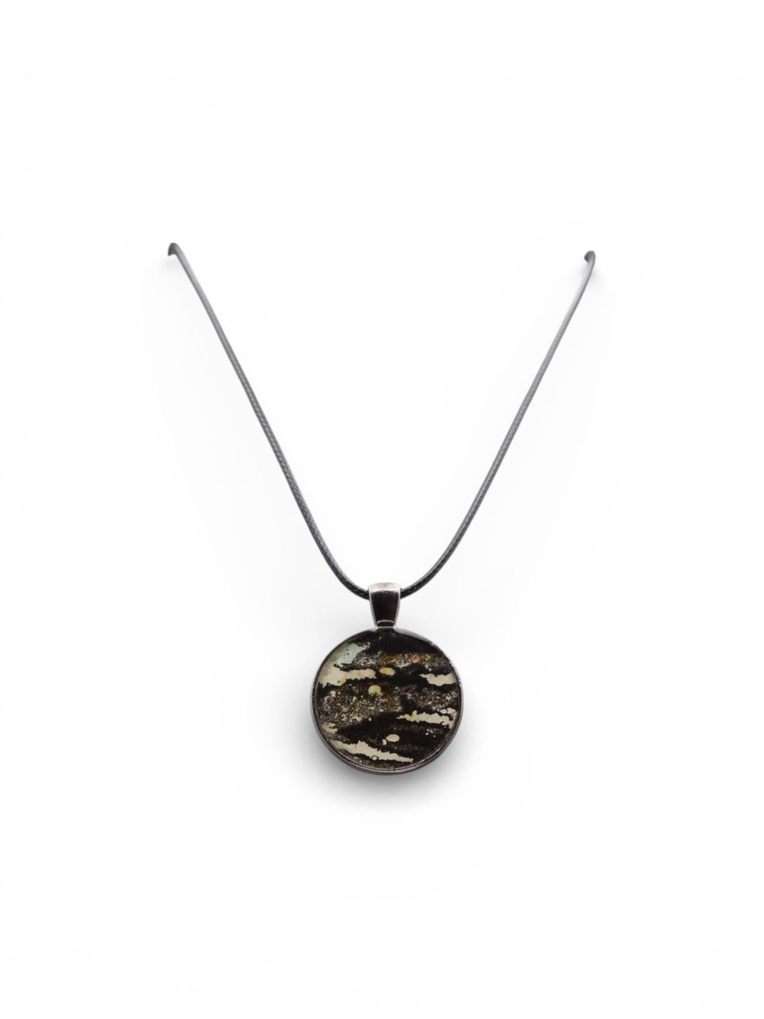 Dark round pendant necklace on a white background