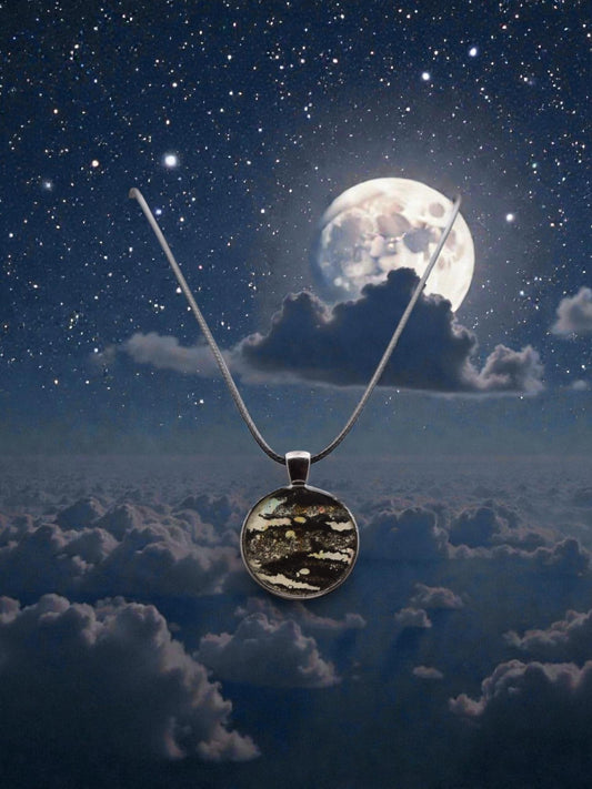 Necklace with a pendant against a night sky with clouds and moon
